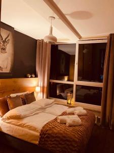 a bedroom with a bed with two towels on it at Apartament SPA 52 Resort Kozubnik blisko Szczyrk- 5D Apartamenty in Porąbka
