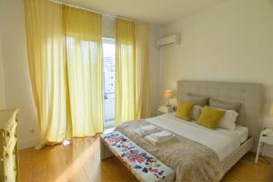 Schlafzimmer mit einem großen Bett und gelben Vorhängen in der Unterkunft Pinpoint Porto Apartment by Porto City Hosts in Porto