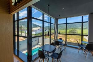 een kamer met tafels en stoelen en een groot raam bij Elephant Office Brasil in Governador Celso Ramos