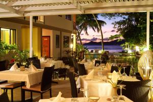 un restaurant avec tables et chaises avec vue sur l'océan dans l'établissement Le Repaire - Boutique Hotel & Restaurant, à La Digue