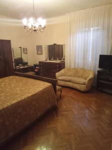 ein Schlafzimmer mit einem Bett, einem Stuhl und einem Spiegel in der Unterkunft AFFITTACAMERE VILLA SOFIA accanto Ospedale con ampio giardino in Fano