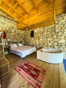 a bedroom with a bed and a bath tub at Shavilla Kalkan - Yalı ' da Korunaklı 1+1 Villa in Patara