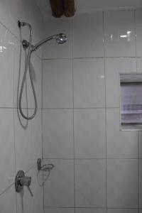 y baño con ducha con cabezal de ducha. en Hostal Turistico ILLAPA CUSCO 119, en Cusco