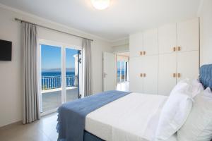 a bedroom with a bed and a view of the ocean at Kavos House in Spartokhórion