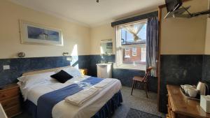 a hotel room with a bed and a window at Argyle Lodge Self Catering Guest House in Southampton