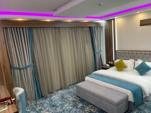 a hotel room with a large bed and a purple light at Mabeet Residances in Abha