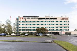 a santander building with cars parked in a parking lot at Scandic Espoo in Espoo