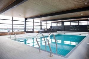 a large swimming pool in a building with a view at Scandic Espoo in Espoo