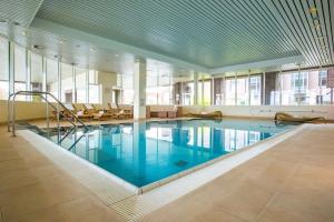 a large swimming pool in a large room with windows at Radisson Blu Senator Hotel, Lübeck in Lübeck