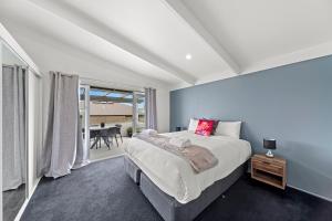 um quarto com uma cama grande e uma mesa em Hilltop House - Taupo em Taupo