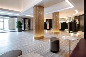 um lobby com colunas e mesas e um bar em Radisson Blu Hotel, Antwerp City Centre em Antuérpia