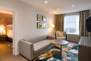 a living room with a couch and a table and a bed at Radisson Blu Hotel, Antwerp City Centre in Antwerp