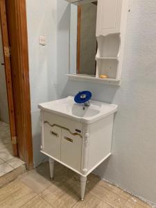 a white bathroom sink with a blue bowl on it at روز الهدا in Al Hada