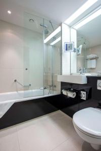 uma casa de banho com um chuveiro, um WC e um lavatório. em Radisson Blu Hotel, Hamburg em Hamburgo