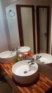 baño con 2 lavabos y espejo grande en Accueillant Salta en Salta