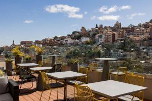 a patio with tables and chairs and a view of a city at Radisson Serviced Apartments Antananarivo City Centre in Antananarivo