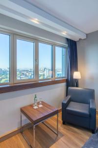 sala de estar con silla, mesa y ventanas en Radisson Blu Hotel, Hamburg en Hamburgo