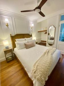 Schlafzimmer mit einem großen weißen Bett und einem Deckenventilator in der Unterkunft Ultima- Unique elegance in Port Douglas in Port Douglas