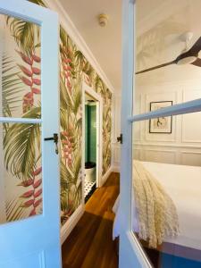 eine Tür, die in ein Schlafzimmer mit einer tropischen Tapete führt in der Unterkunft Ultima- Unique elegance in Port Douglas in Port Douglas