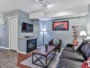 uma sala de estar com um sofá e uma lareira em **NEW** Cozy Rocky Mountain Chalet with Park Pass em Canmore