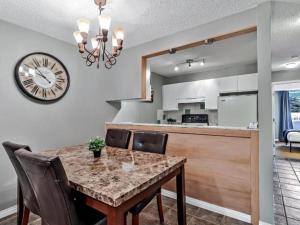 uma mesa de jantar com cadeiras e um relógio na parede em **NEW** Cozy Rocky Mountain Chalet with Park Pass em Canmore