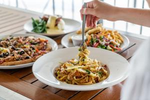 a person eating a plate of pasta on a table at Capella Hotel Motel in Capella