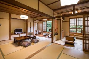 a living room with a table and a tv at Yamabiko Ryokan in Minamioguni