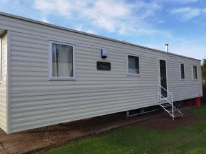 a white trailer with a sign on the side of it at Little Heaven self-catering caravan in Church Farm Holiday Park in Pagham