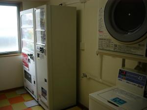 奈良的住宿－奈良微笑酒店，厨房里配有冰箱,厨房旁边设有微波炉