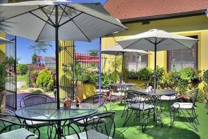 un patio al aire libre con mesas, sillas y sombrillas en Hotel Elzet, en Tábor