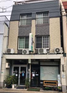 un edificio con un banco delante de él en Hotel Villa Dogo, en Matsuyama