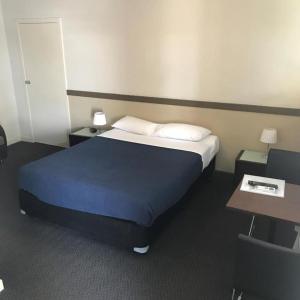 a hotel room with a bed and a desk at Highlander Hotel Bar Kitchen Rooftop in Adelaide