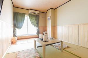 a room with a table and a window at Hotel Villa Dogo in Matsuyama