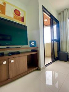 uma sala de estar com uma grande TV de tela plana em Apartamento Praia da Enseada no Guarujá
