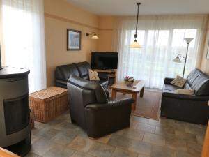 a living room with leather furniture and a tv at "Tau Hus" im "Roden Hus" in Timmendorf