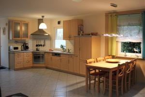 a kitchen with a wooden table and a dining room at Dwarslöper in Am Schwarzen Busch