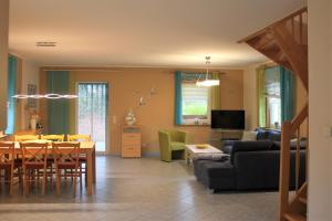 a living room with a couch and a dining room at Dwarslöper in Am Schwarzen Busch