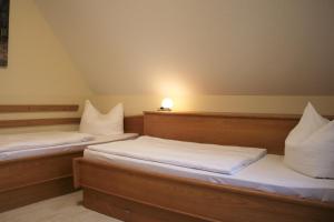 two beds in a room with a light on the wall at Dwarslöper in Am Schwarzen Busch