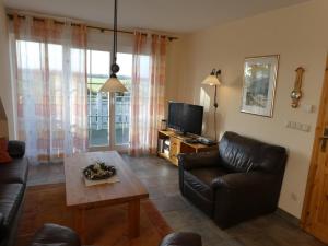 a living room with a couch and a tv at "Utkiek" im "Roden Hus" in Timmendorf