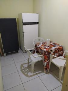 a kitchen with a table and chairs and a refrigerator at Hospedaria in Recife