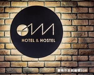 a sign for a hotel and hostel on a brick wall at Oinn Hotel & Hostel Tainan in Tainan