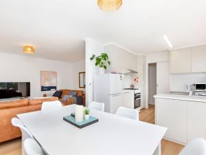 a white kitchen and living room with a white table and chairs at MaryMae in Port Fairy +7 photos
