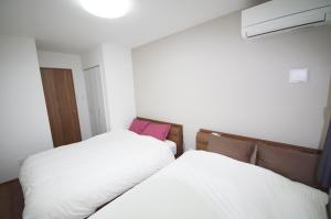two beds sitting next to each other in a room at Plage Garden Place A-111 in Miyako Island