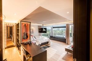 ゴヴェルナドール・セウソ・ラーモスにあるElephant Office Brasilのベッドルーム1室(ベッド1台、ギター付)