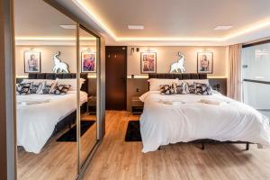 ゴヴェルナドール・セウソ・ラーモスにあるElephant Office Brasilのベッド2台と大きな鏡のある寝室 +49枚の写真