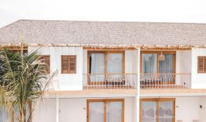 a white house with windows and a palm tree at Canggu Village Accommodation in Canggu