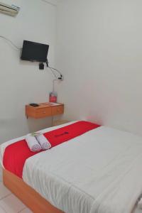 1 dormitorio con 1 cama y TV en la pared en RedDoorz near GOR UNY, en Demangan