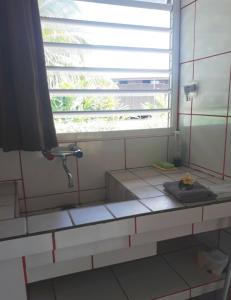 uma casa de banho com um lavatório e uma janela em Chez Mimi et Daniel em Bora Bora