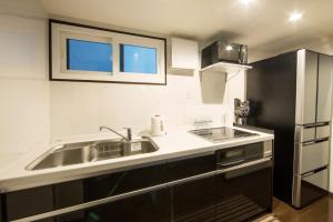 a kitchen with a sink and a stainless steel refrigerator at Rinn Kiyomizu Villa in Kyoto