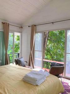 1 dormitorio con cama y ventana grande en บ้านชายดอย Glamping ดอยแม่แจ๋ม cheason ,Muangpan, Lampang, en Ban Mai
